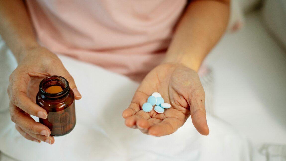 mujer mayor con varias benzodiazepinas en la mano